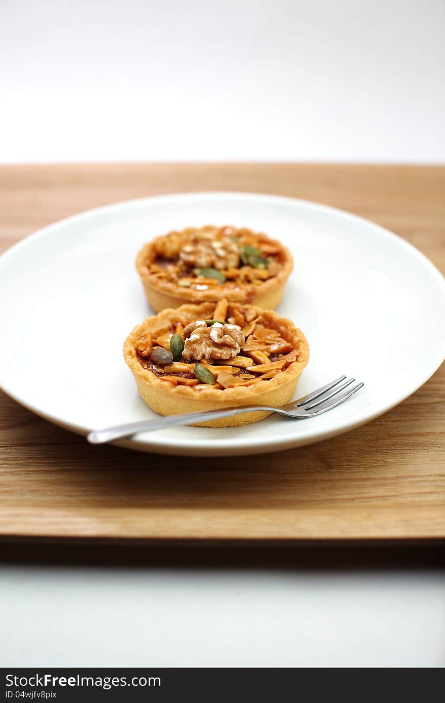 Two cup cake , caramel nuts tart on white background