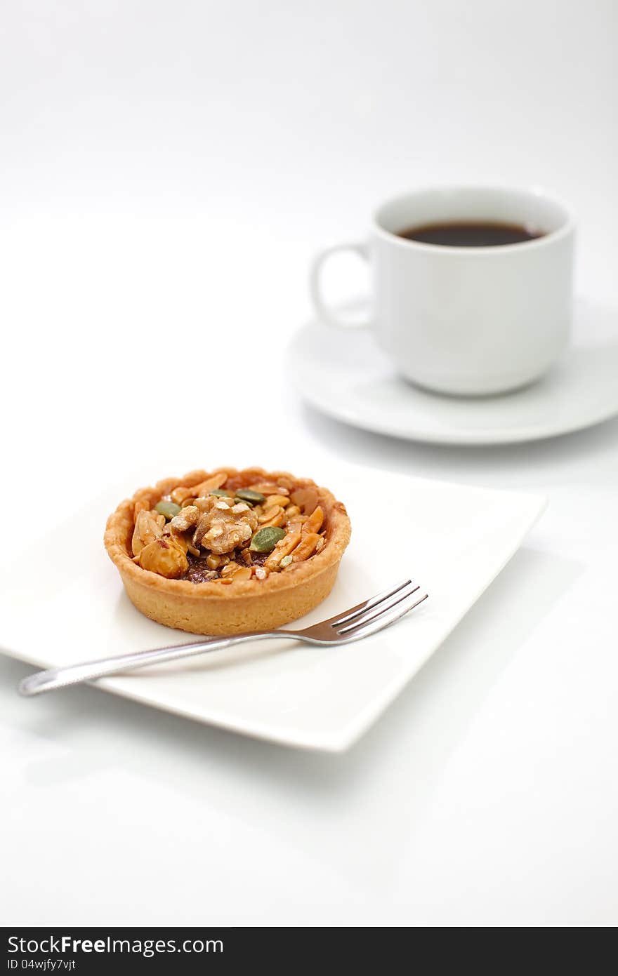 cup cake , caramel nuts tart and a cup of coffee on white background