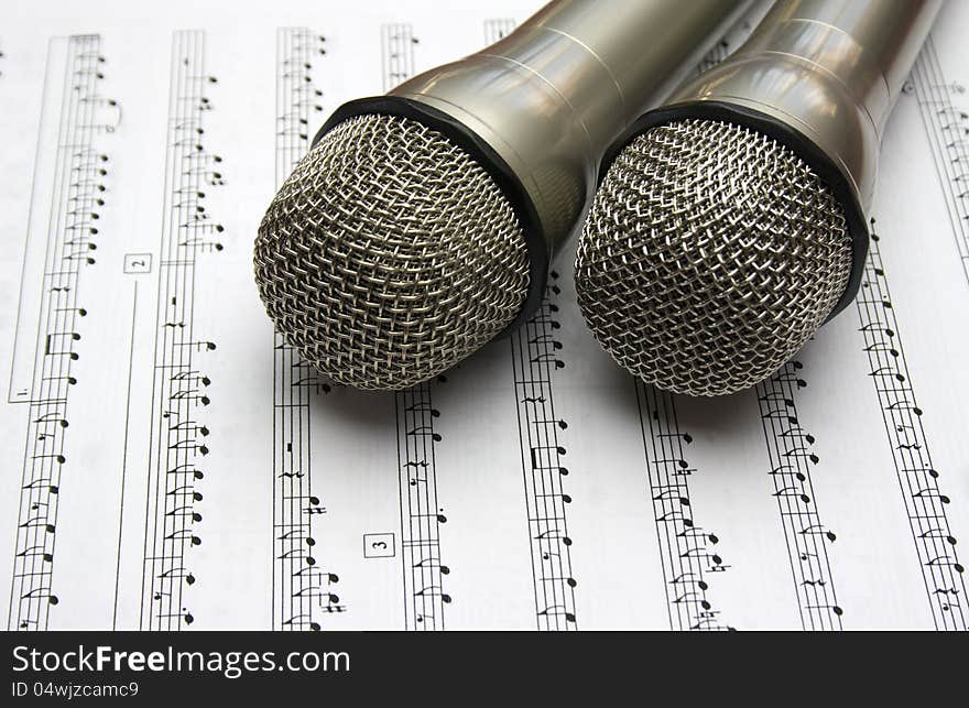 Two metal microphone with music notes. Two metal microphone with music notes