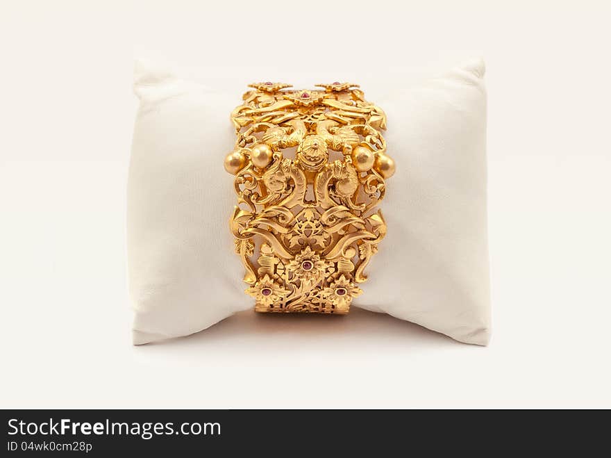 Pure Gold bracelet having itself craft of gold looking historic over white background with soft cushion. Pure Gold bracelet having itself craft of gold looking historic over white background with soft cushion