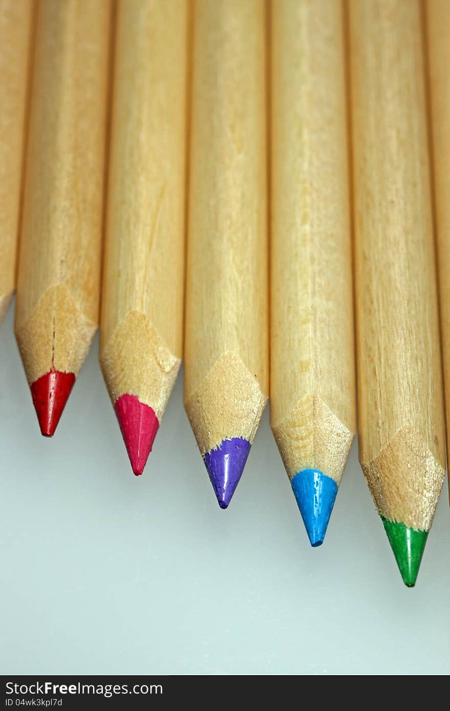 Wooden coloured pencils in line on white background