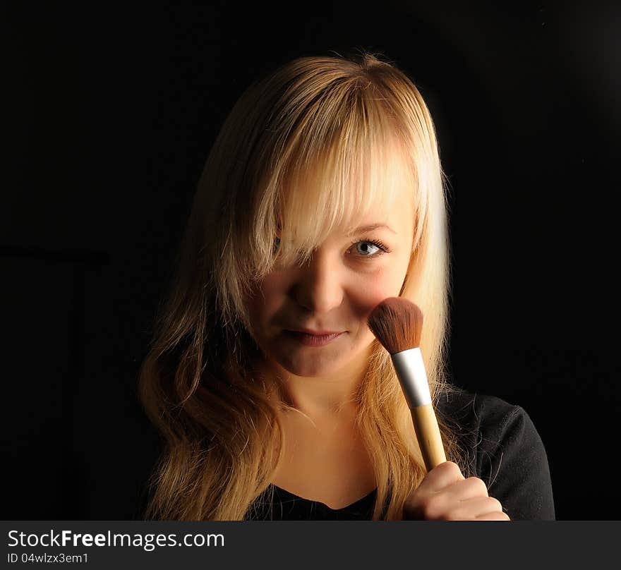 Young Blond Hair Woman Portrait  With Make-up Brush On Dark Background