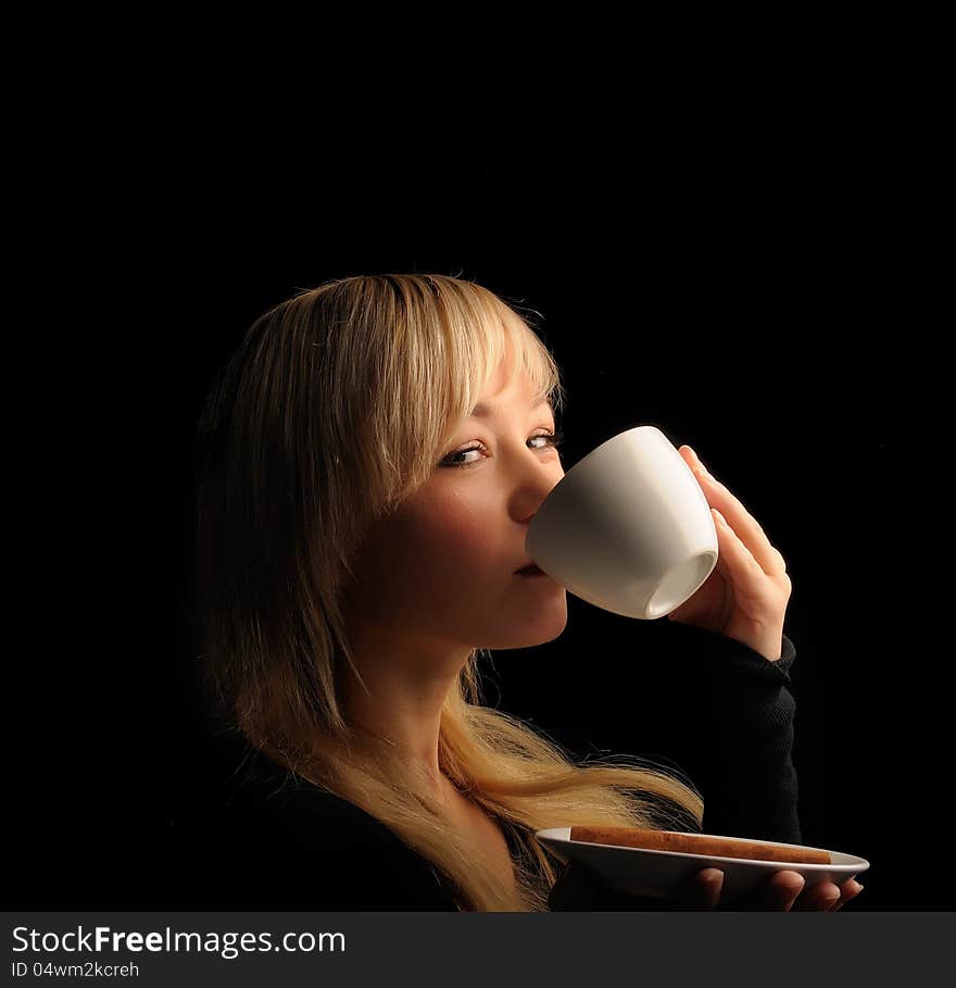 Young blond hair woman with coffe  on a dark background. Young blond hair woman with coffe  on a dark background.