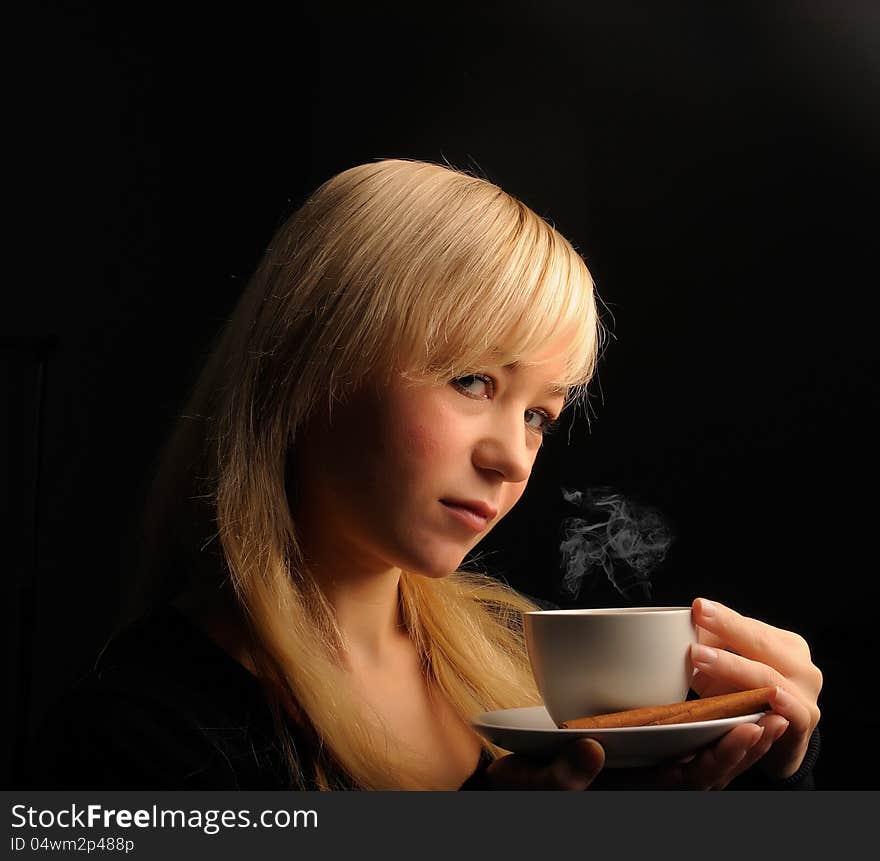 Young  woman with coffe  on a dark background