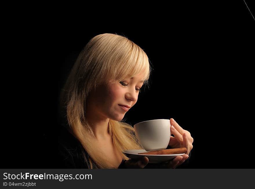 Young blond hair woman with coffe  on a dark background. Young blond hair woman with coffe  on a dark background.