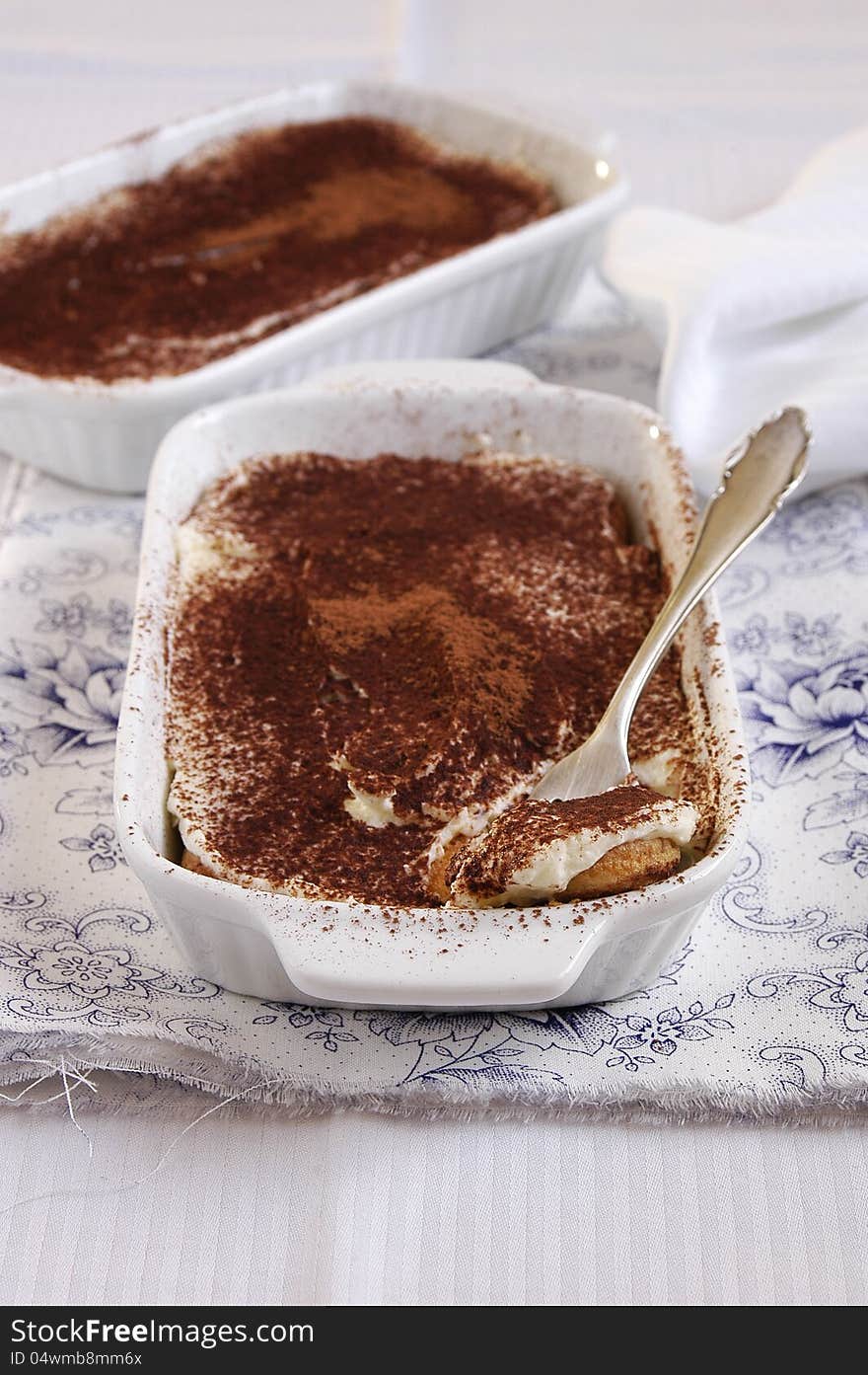 Small desserts with mascarpone cream and cocoa in baking forms. Small desserts with mascarpone cream and cocoa in baking forms