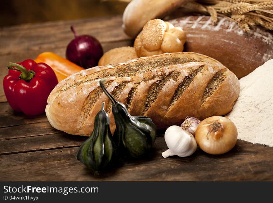 Green pumpkins near vegetables and bread on wood table. Green pumpkins near vegetables and bread on wood table