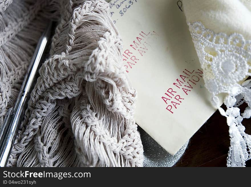 Close up air mail letter put under wool scarf in winter