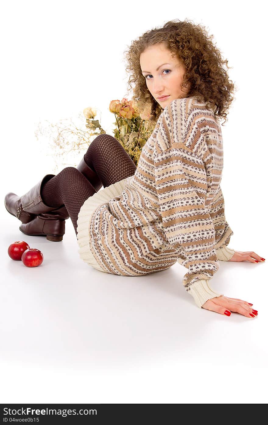 Girl sits in a cozy sweater isolated