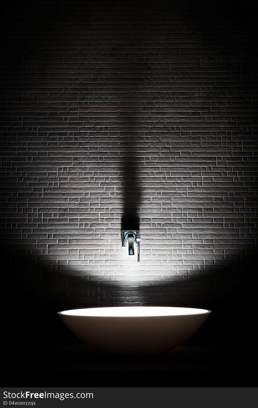 Black tile on the wall and white dish in the bathroom. Black tile on the wall and white dish in the bathroom