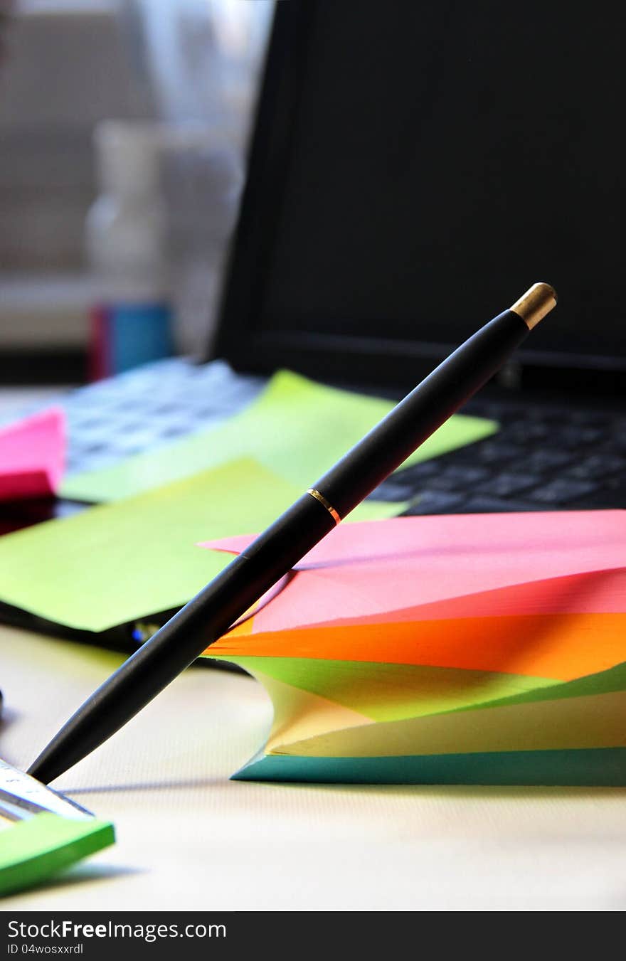 Mix of office stationery - computer, pen, note papers