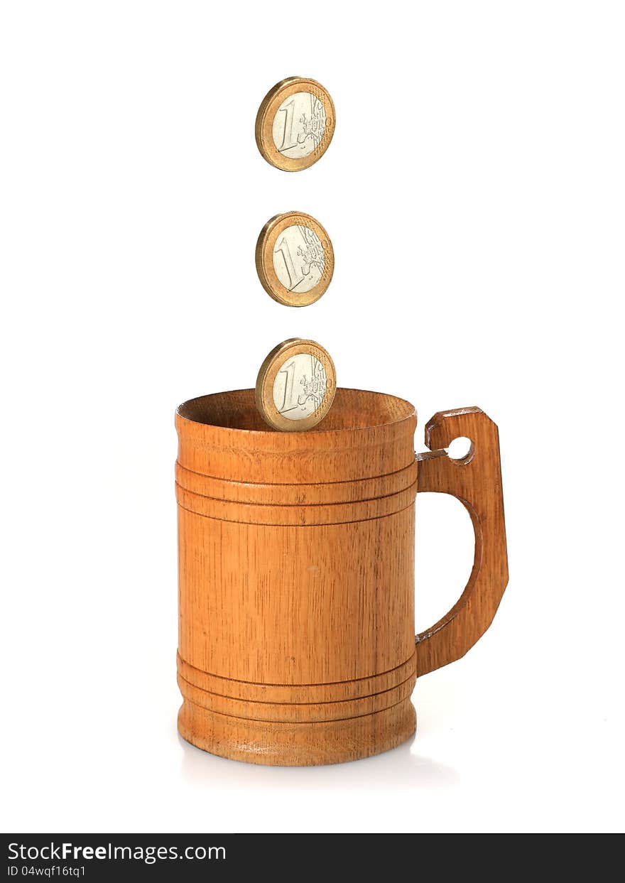 Wooden mug and coins isolated over white. Wooden mug and coins isolated over white.