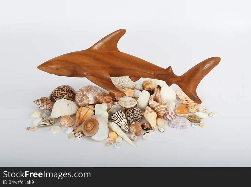 Wooden Carved Shark Hovering Over Seashells. Wooden Carved Shark Hovering Over Seashells