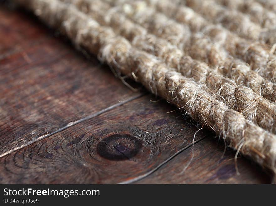 Closeup of old hemp rope on dark wooden surface. Closeup of old hemp rope on dark wooden surface