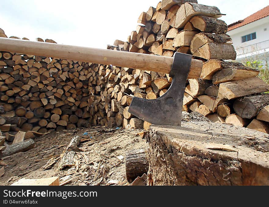 DRAMA, GREECE - OCT 8: Wood axe and wood pile outdoor prepared for winter on October 4, 2010 in Drama,Greece. DRAMA, GREECE - OCT 8: Wood axe and wood pile outdoor prepared for winter on October 4, 2010 in Drama,Greece.