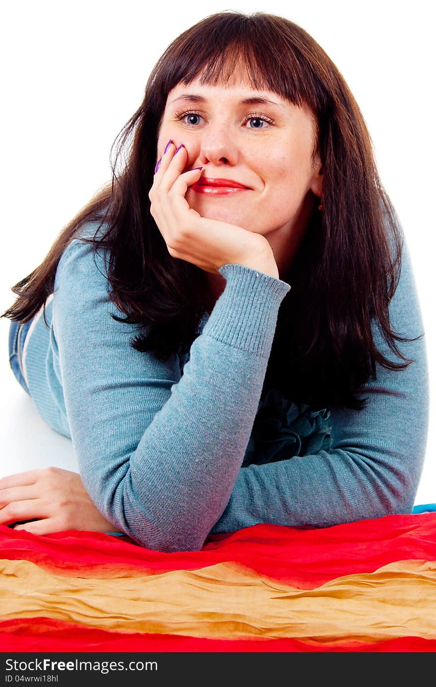 The girl poses while lying on the floor isolated on white background