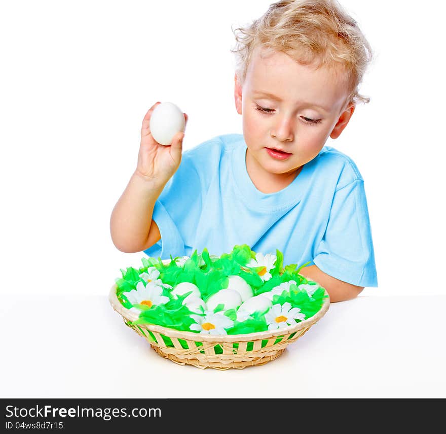 Boy sitting at a table covered with a basket of eggs. Boy sitting at a table covered with a basket of eggs