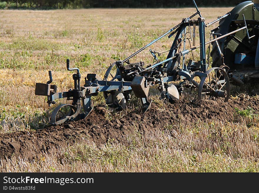 A Vintage Plough Cutting a Furrow in a Field. A Vintage Plough Cutting a Furrow in a Field.