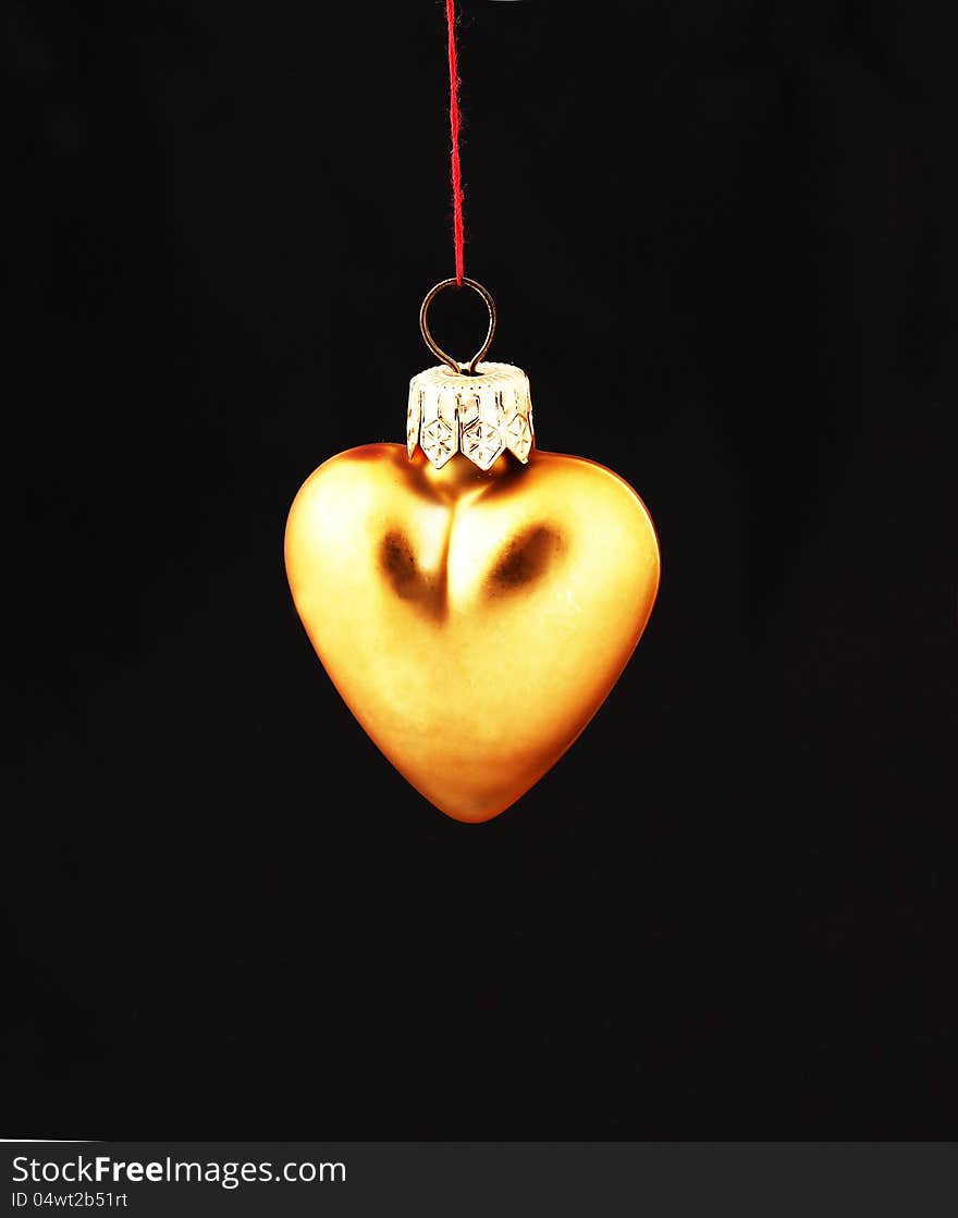 Hanging Christmas yellow heart  isolated on black background. Hanging Christmas yellow heart  isolated on black background