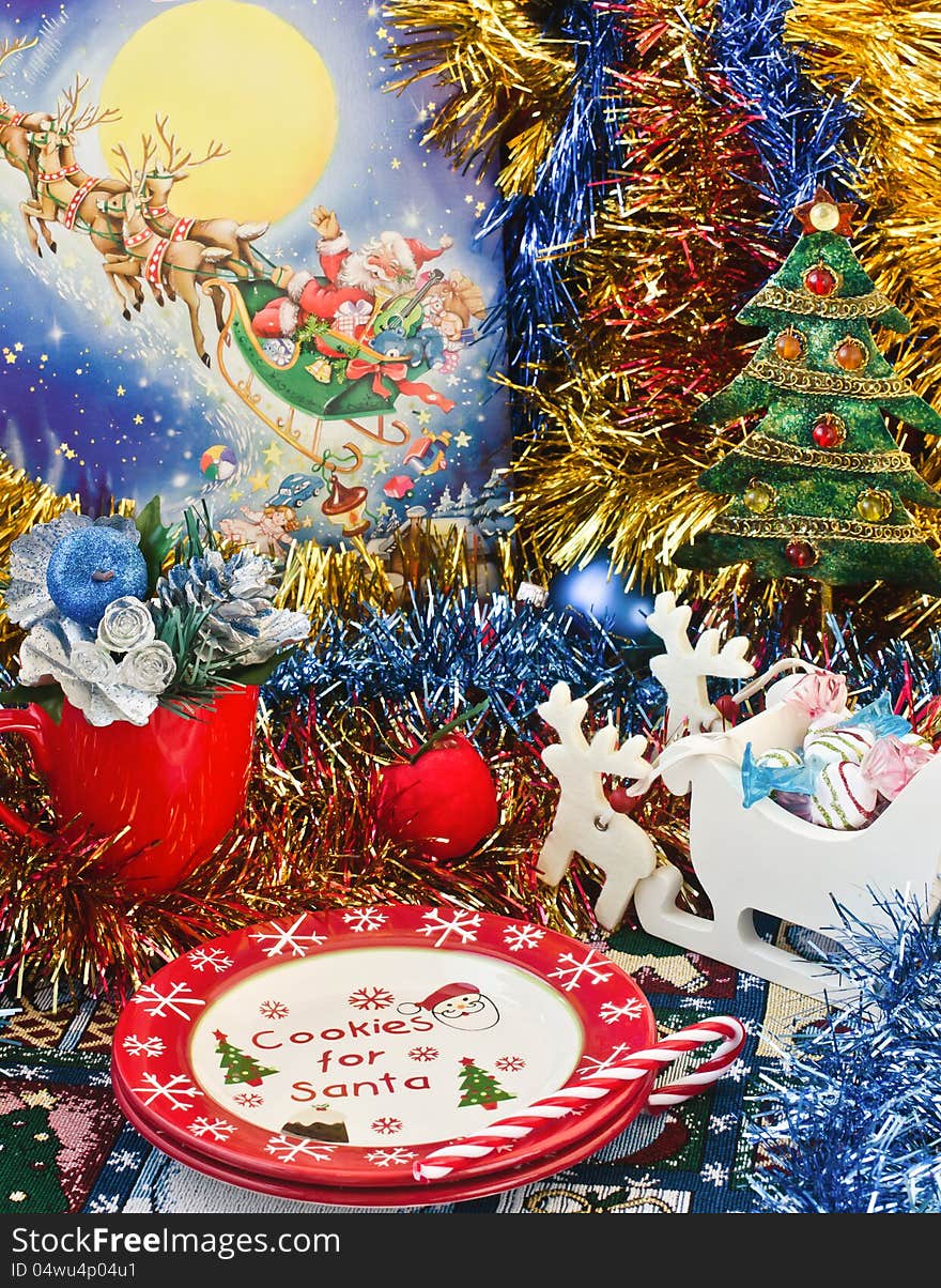 Christmas table arrangement with blue tinsel. Cookie for Santa plates.