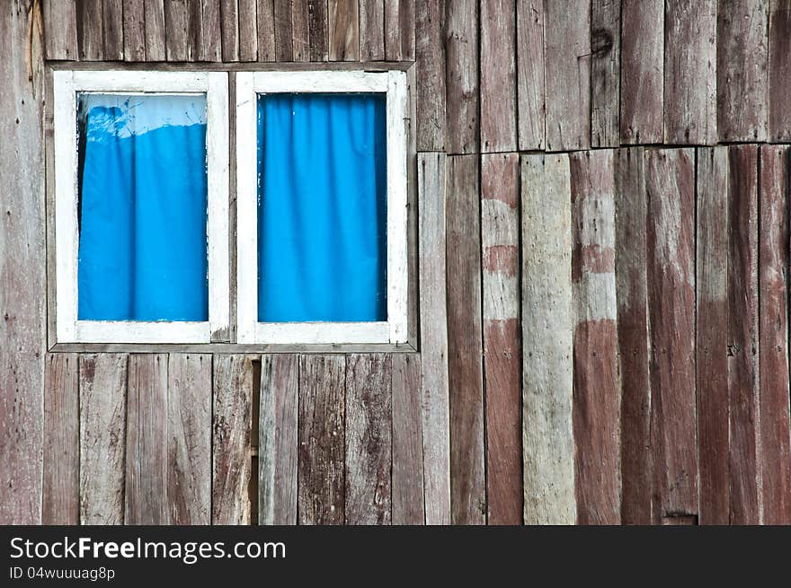 A window that have white frame and blue curtain