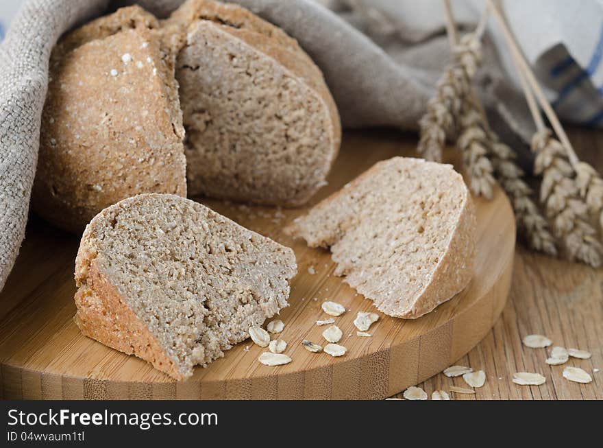 Bread with oat flakes chopped to pieces on a wooden board