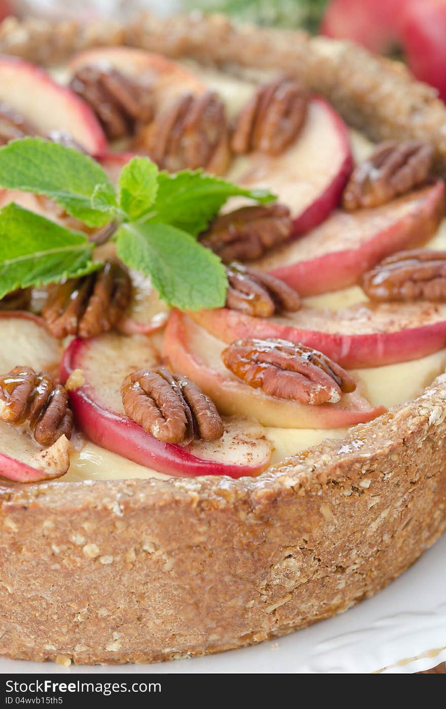 Cheesecake with apples and caramelized pecans closeup, selective focus