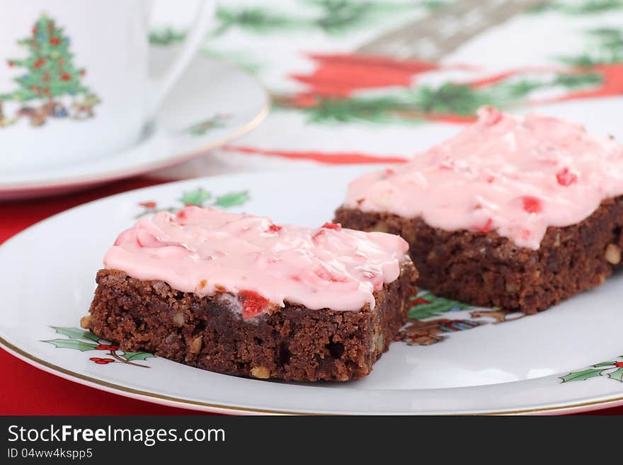 Two Christmas brownies with cherry icing on a plate