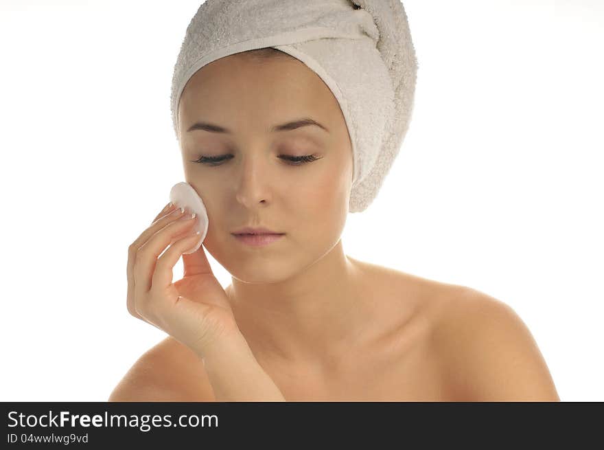 Close-up portrait of young beautiful woman with cotton swab cleaning her face