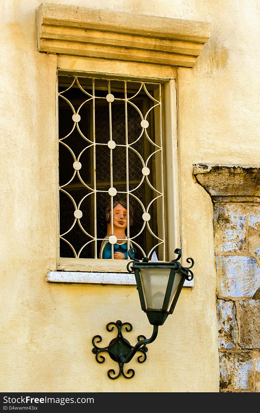 Old-school windows with a lamp and a sculpture of a child in the windows