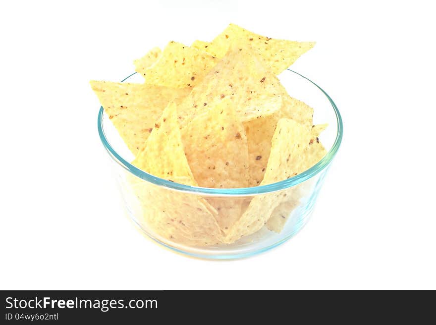 Corn tortilla chips in glass bowl isolated on white. Corn tortilla chips in glass bowl isolated on white