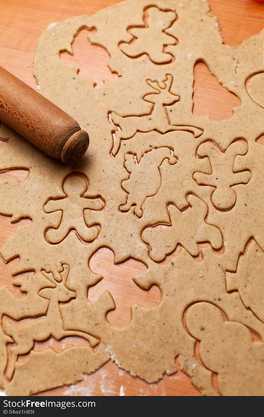 Gingerbread cookie dough cut to christmas themed shapes. Gingerbread cookie dough cut to christmas themed shapes