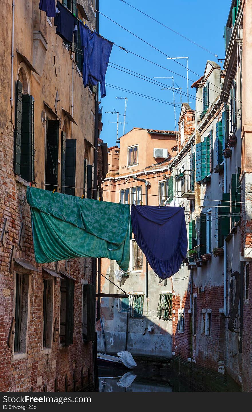 Clothes hanging out to dry between the buildings over a small canal in Venice,Italy. Clothes hanging out to dry between the buildings over a small canal in Venice,Italy.