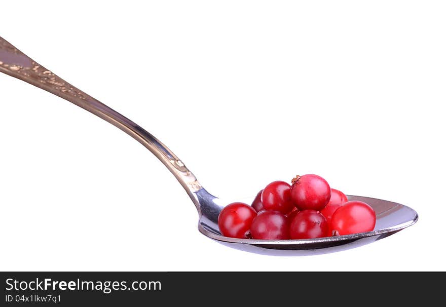 Сranberries on a spoon; silver spoon;