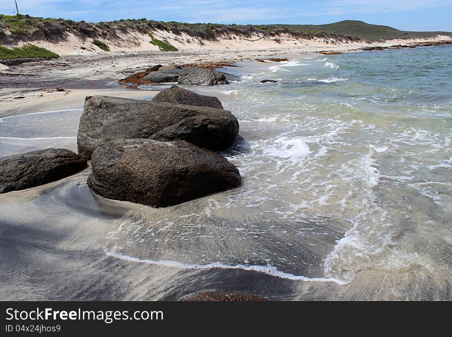 The rocky beach at Augusta Western Australia where the deep blue  Southern Ocean laps the pure white sand overlaid with mineral deposits  is a favourite fishing location.