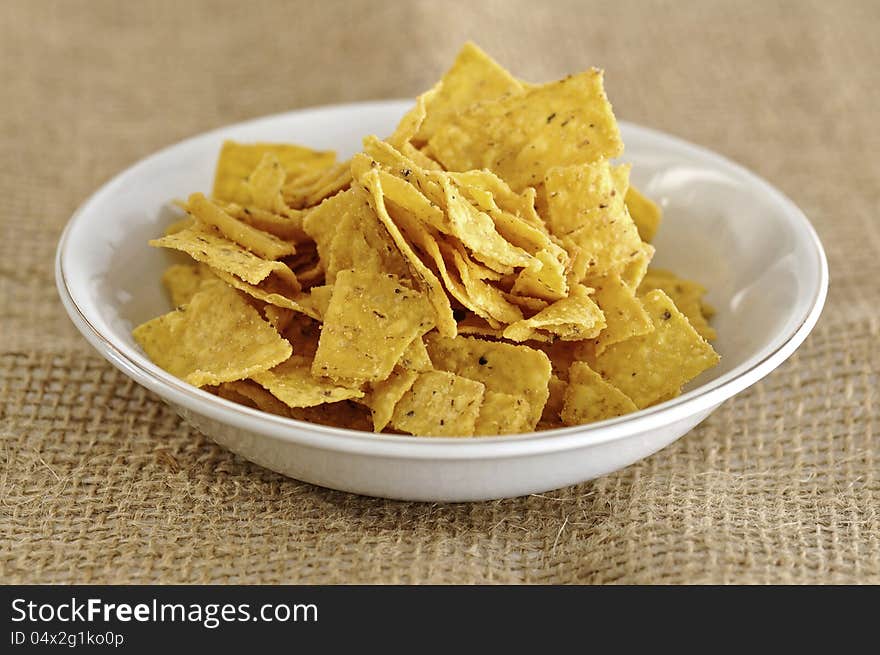 Nachos snack in the bowl on the burlap background. Nachos snack in the bowl on the burlap background