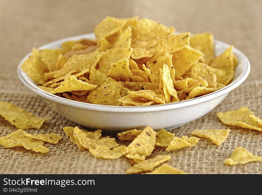 Nachos snack in the bowl on the burlap background. Nachos snack in the bowl on the burlap background