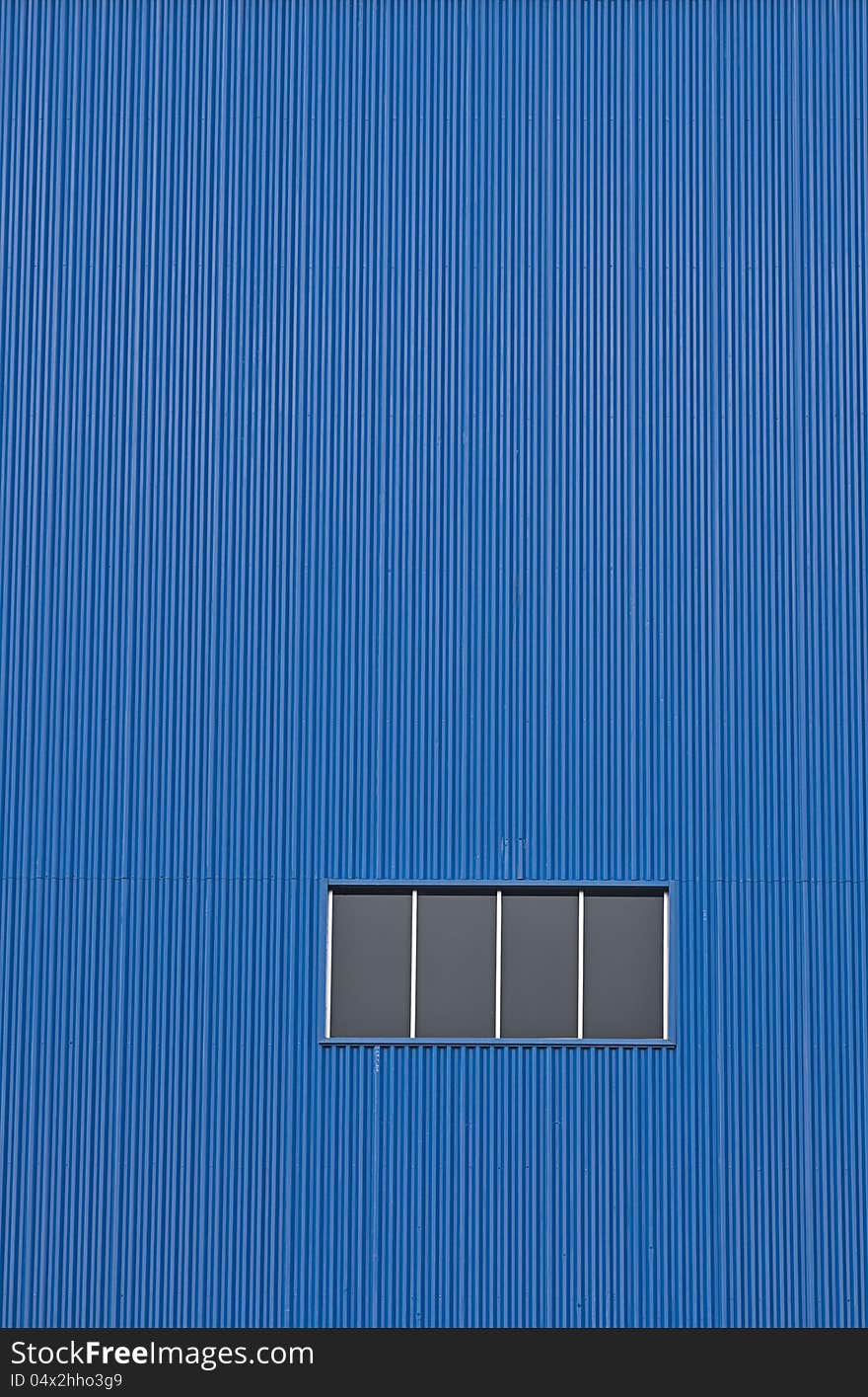 Factory window on blue wall. An industrial abstract