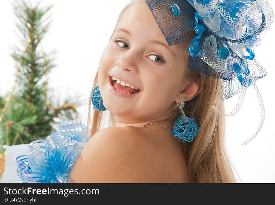 Portrait of a cute little girl in a beautiful dress and ornaments for the head against the Christmas tree. Portrait of a cute little girl in a beautiful dress and ornaments for the head against the Christmas tree