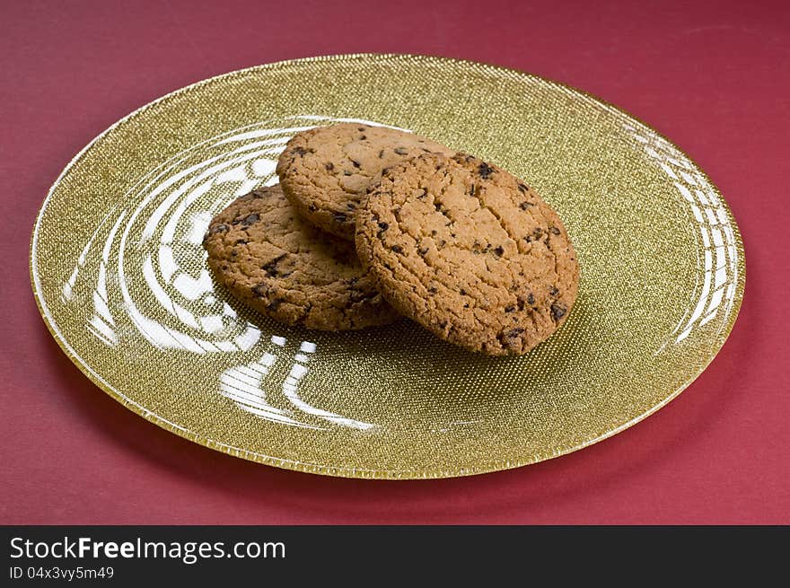 Chocolate cookies on a plate over color background