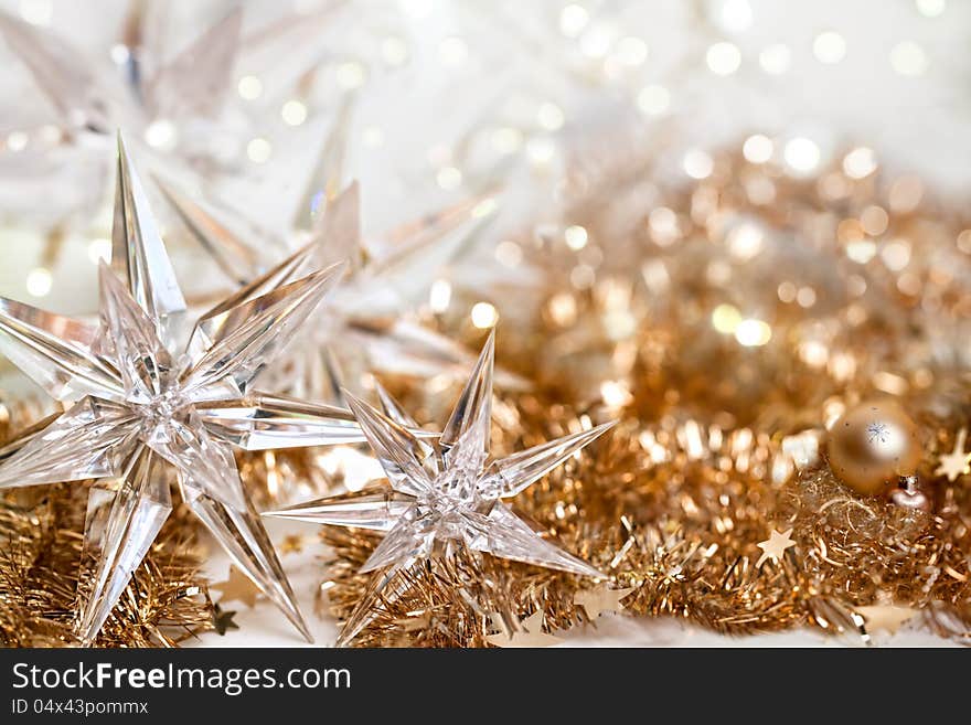 Christmas background with stars of glass on golden ribbons and defocused lights. Christmas background with stars of glass on golden ribbons and defocused lights