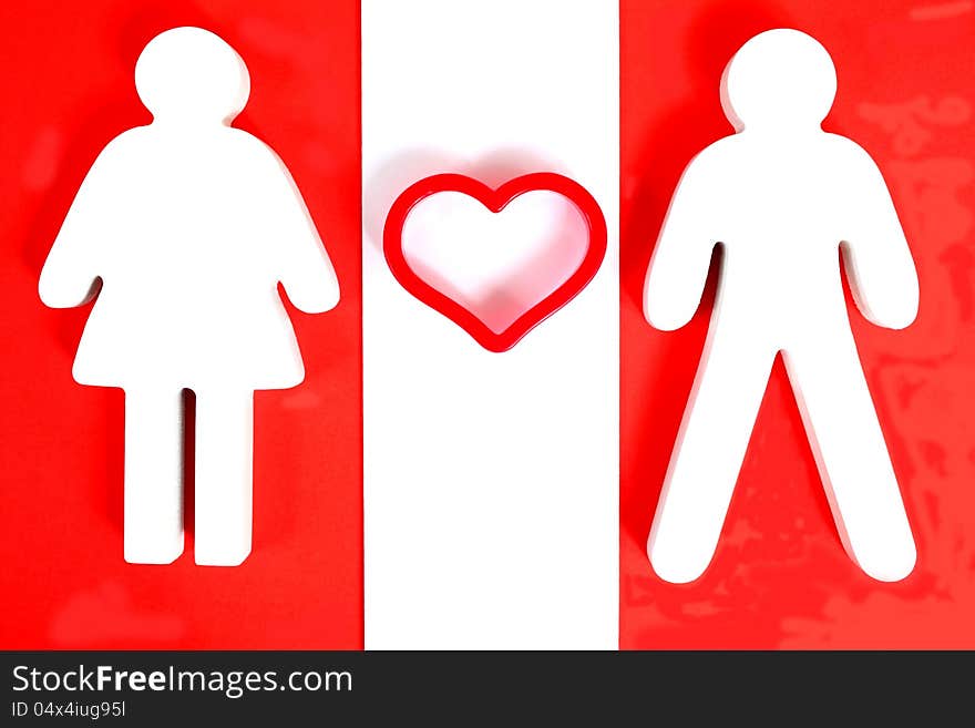 Wooden male and female figure with red heart between them. Wooden male and female figure with red heart between them