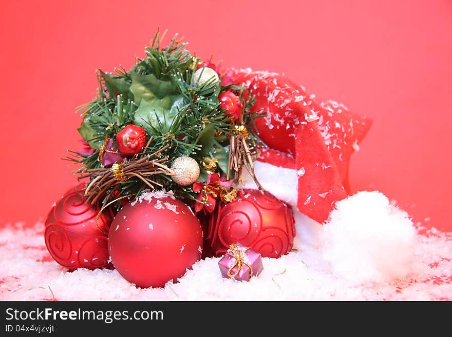 Santa Claus hat with tree ornaments on a red background. Santa Claus hat with tree ornaments on a red background