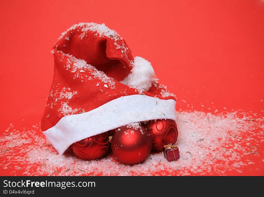 Santa Claus hat with tree ornaments on a red background. Santa Claus hat with tree ornaments on a red background