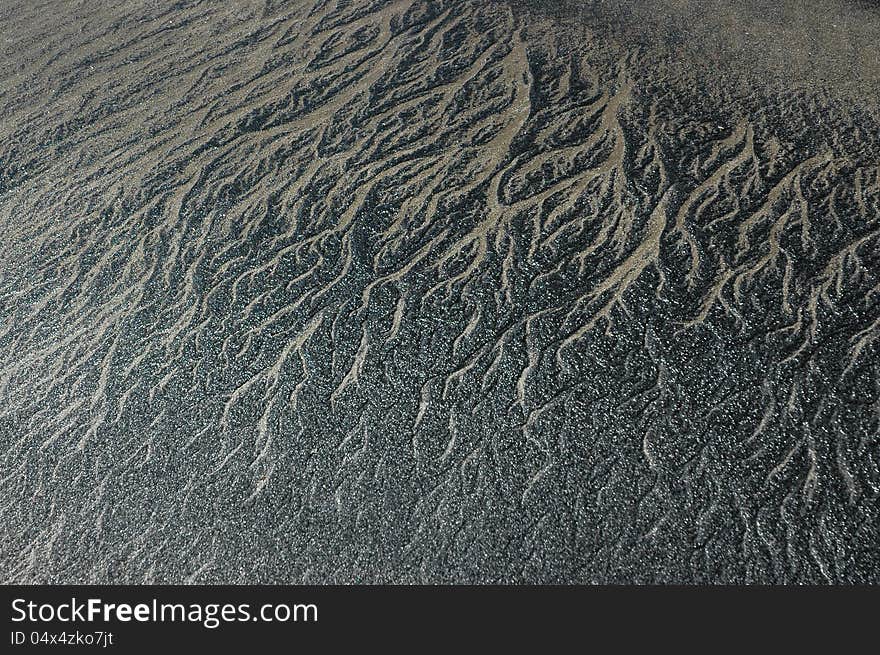 Abstract patterned background with black and gray sand of coastal India. Abstract patterned background with black and gray sand of coastal India