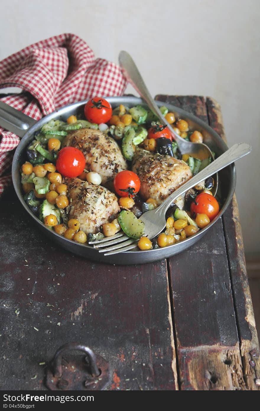 Roasted chicken with cherry tomatoes, courgette, eggplant and chickpea in a pan. Roasted chicken with cherry tomatoes, courgette, eggplant and chickpea in a pan