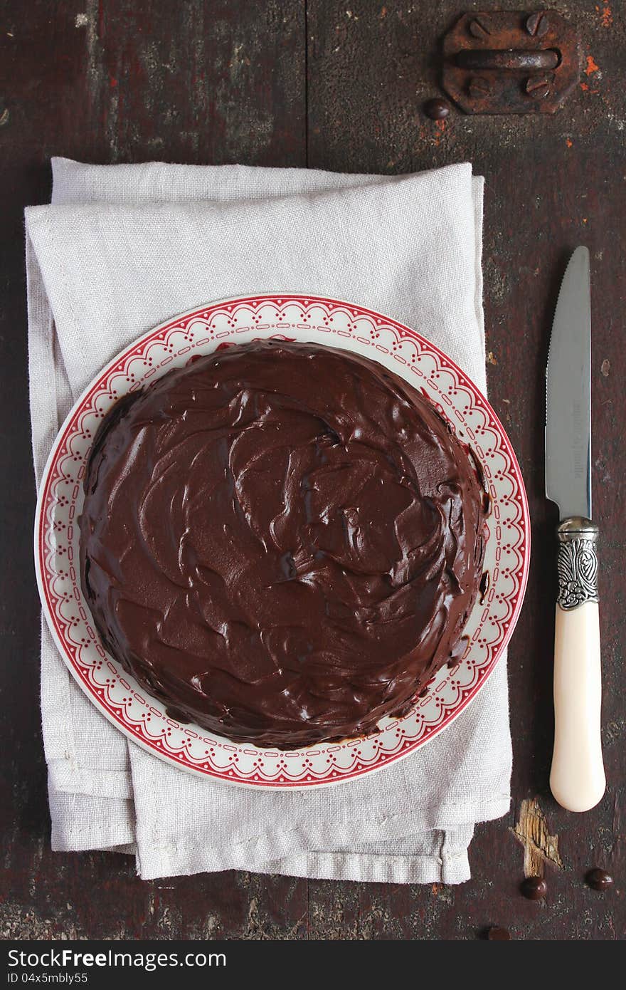 Chocolate cake with chocolate glaze on plate with a knife