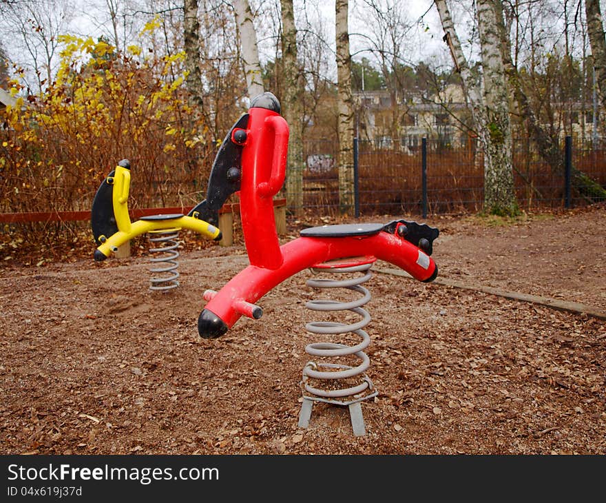 Steel horses, standing alone in a childrens playground. Steel horses, standing alone in a childrens playground