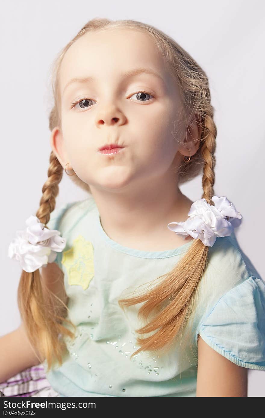 Portrait of a little caucasian fashionable girl with decorative cosmetics indoors