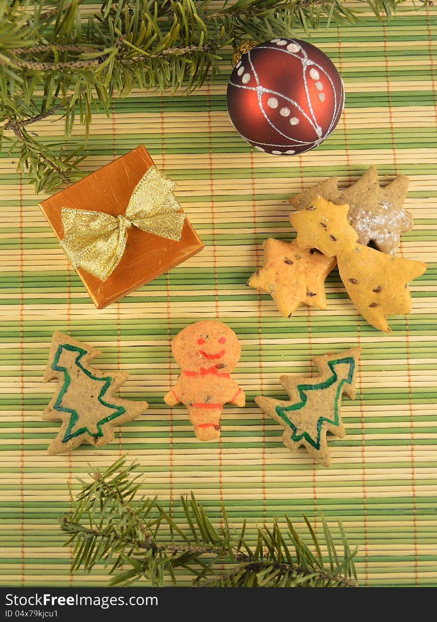 Christmas cookies with the gift and the red ball on the green stripped background. Christmas cookies with the gift and the red ball on the green stripped background